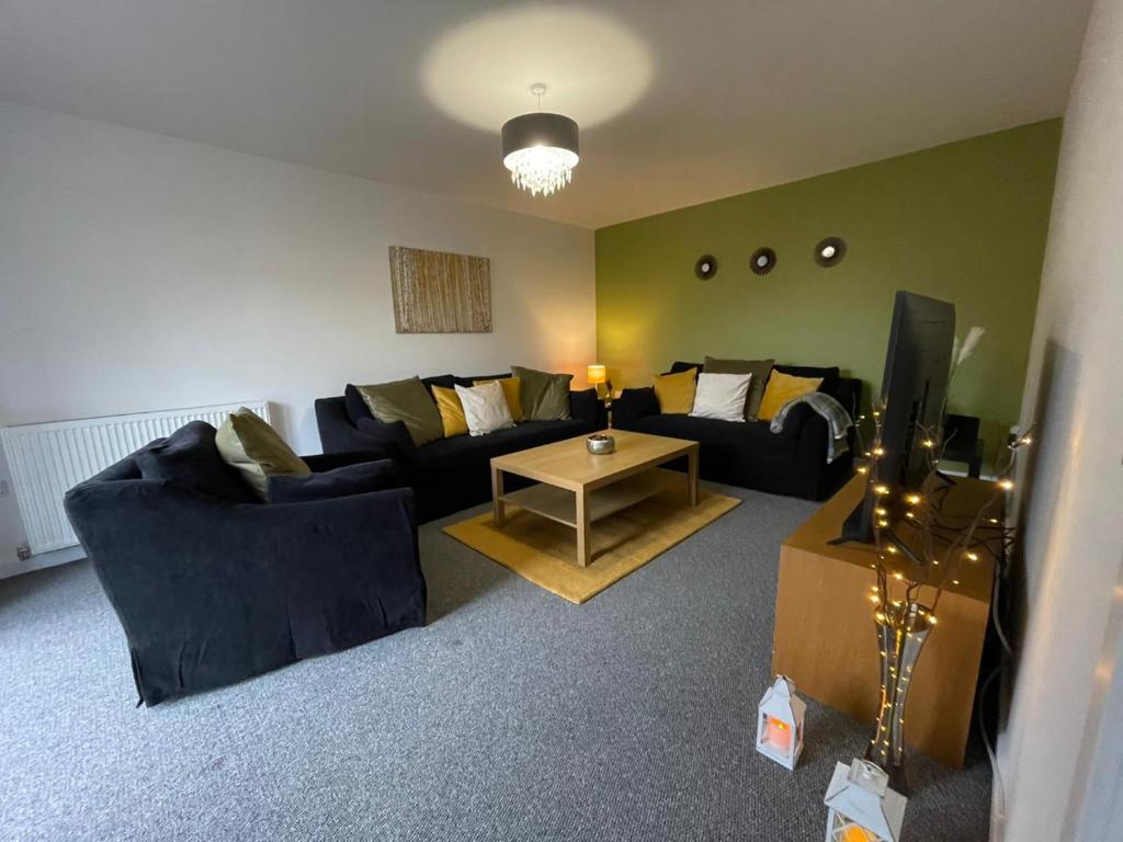 uma sala de estar com dois sofás e uma televisão em The Old Stables 17a em Dumfries