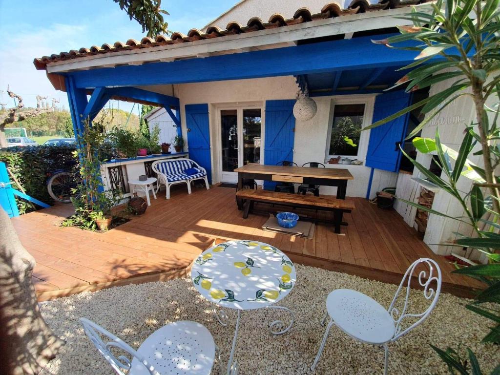 a patio with a wooden deck with chairs and a table at La cabane du pêcheur in Mèze