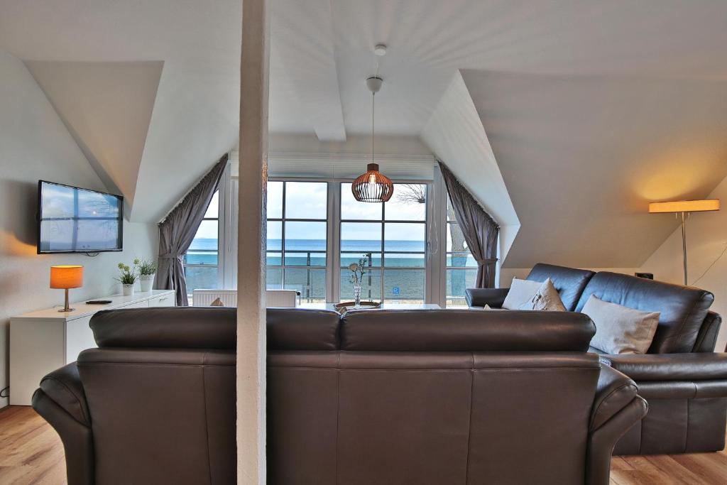 a leather couch in a living room with a view of the ocean at Ostseeblick Ostseeblick Appartement 19 in Scharbeutz