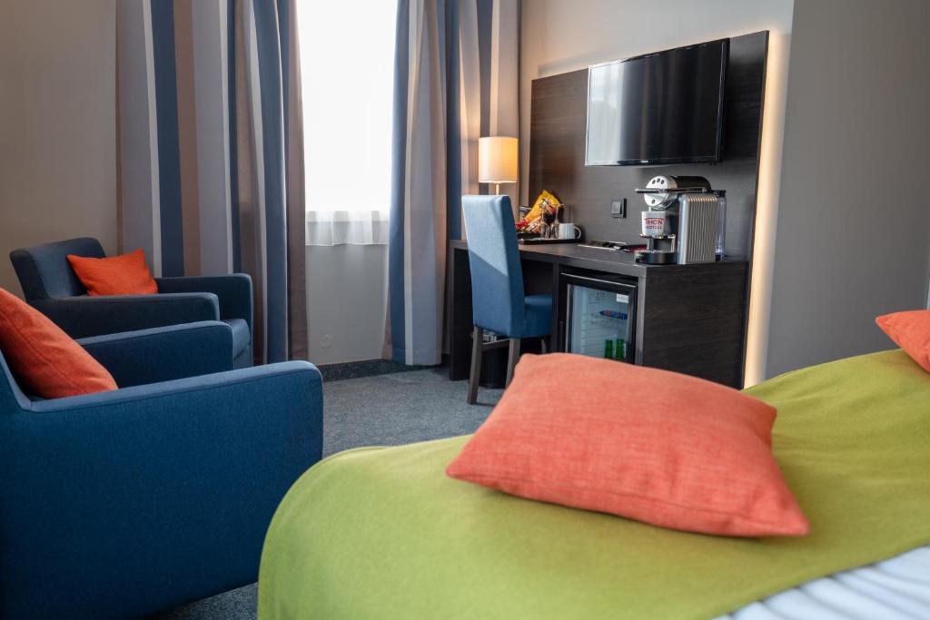 モーレイにあるThon Partner Hotel Måløyのベッドと椅子、キッチン付きのホテルルームです。