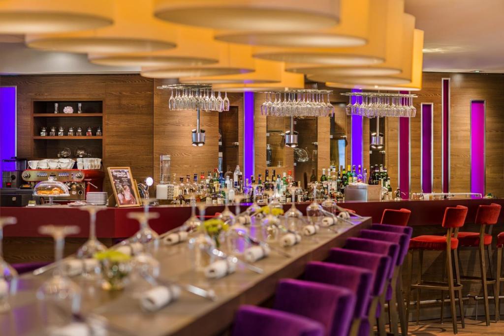 a long table in a restaurant with purple chairs at Clarion Congress Hotel Bratislava in Bratislava