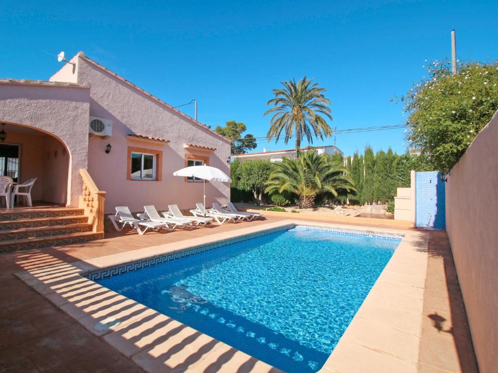 una piscina con sillas y una casa en Villa Dulce Vida by Interhome, en Casas de Torrat