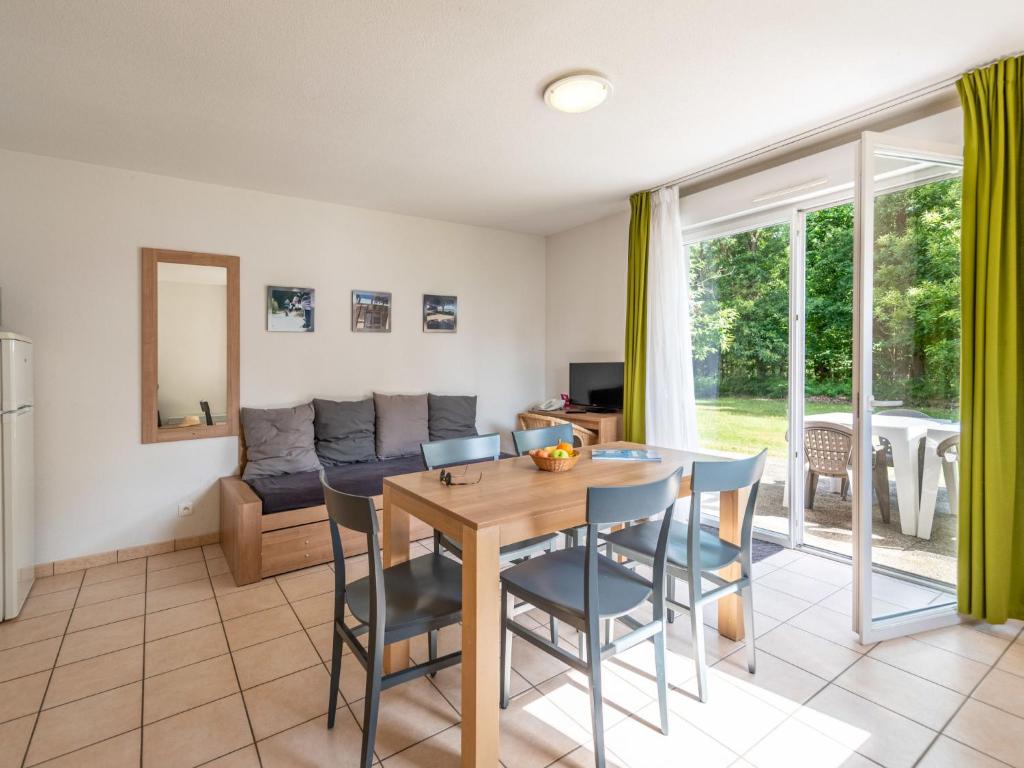 salon ze stołem, krzesłami i kanapą w obiekcie Holiday Home Cottage Confort 5 Pers- by Interhome w mieście Saumur