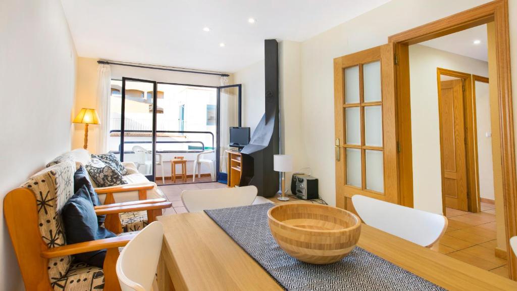 a living room with a table and chairs and a room at 1 Monts - Llafranc in Llafranc
