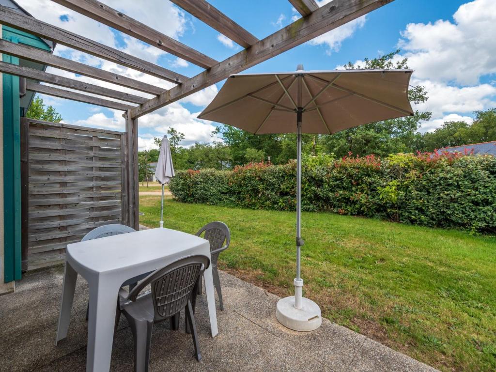 a table and chairs with an umbrella on a patio at Holiday Home Cottage Confort 3 Pers- by Interhome in Saumur