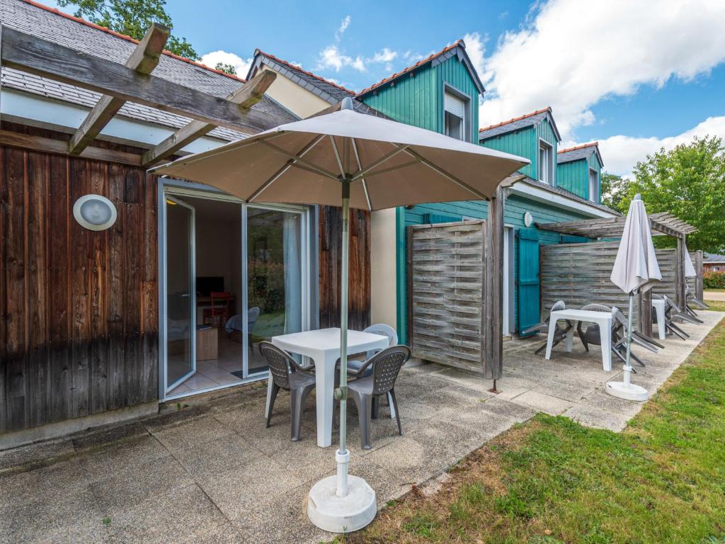 a patio with an umbrella and a table and chairs at Holiday Home Cottage Confort 3 Pers- by Interhome in Saumur