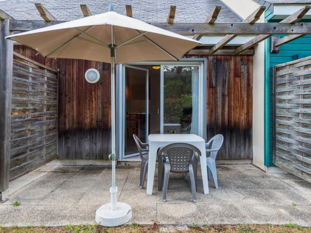 a table and chairs under an umbrella on a patio at Holiday Home Cottage Confort 3 Pers- by Interhome in Saumur