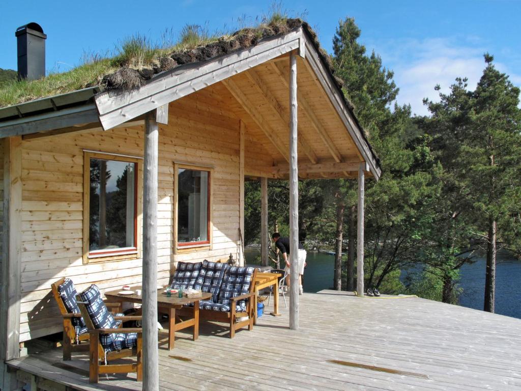 にあるChalet Svanöy by Interhomeのデッキにテーブルと椅子が備わるキャビン