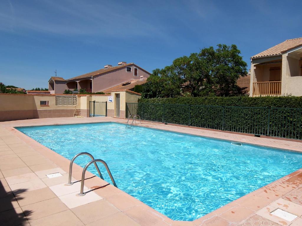 une grande piscine bleue dans une cour dans l'établissement Holiday Home Le Hameau du Rivage by Interhome, à Saint-Cyprien