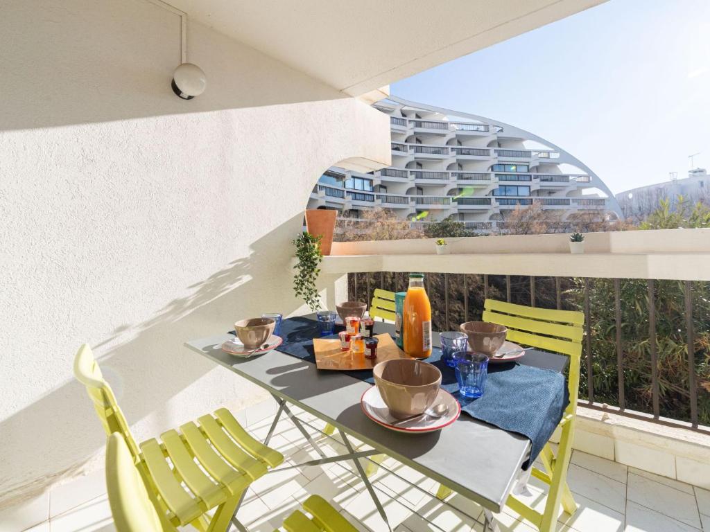 - un balcon avec une table et des chaises dans l'établissement Apartment Ulysse plage 1 by Interhome, à La Grande Motte