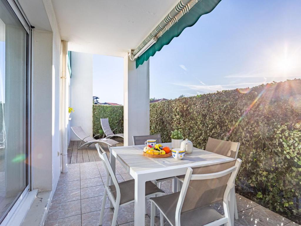 een witte tafel en stoelen op het balkon van een huis bij Apartment Eskola-2 by Interhome in Bidart
