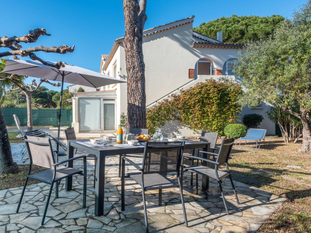 une table avec des chaises et un parasol sur une terrasse dans l'établissement Apartment Lou Niou by Interhome, à Saint-Tropez