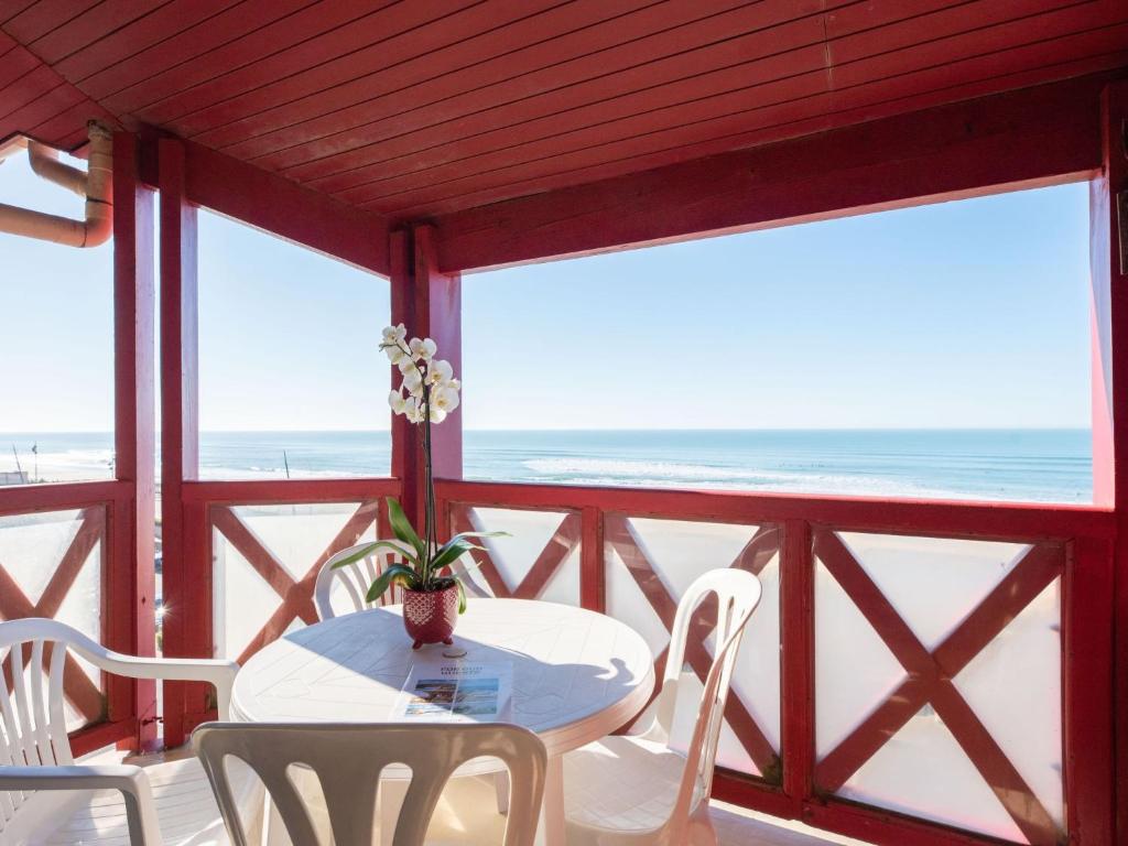 une table et des chaises sur un balcon avec la plage dans l'établissement Apartment Primavéra-10 by Interhome, à Lacanau-Océan