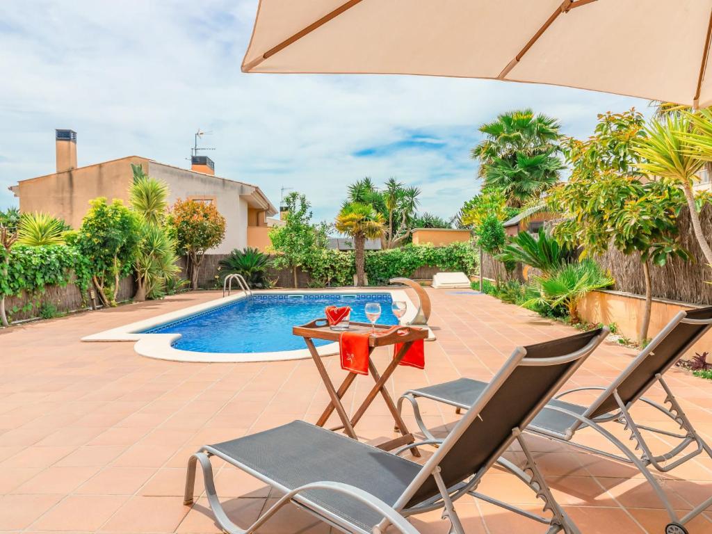un patio con mesa y sillas junto a una piscina en Holiday Home Francaset by Interhome, en Roda de Bará