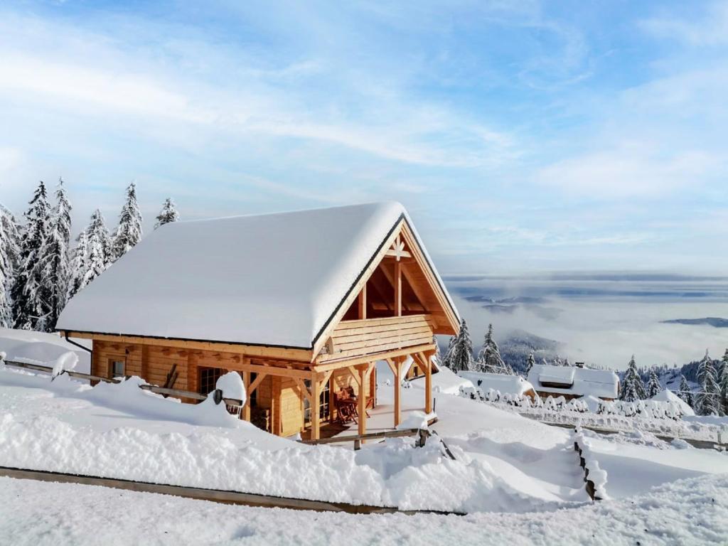 a log cabin covered in snow in the mountains at Chalet Chalet Amsel by Interhome in Hochrindl