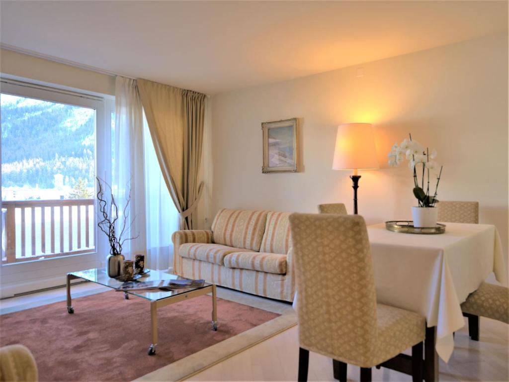 uma sala de estar com uma mesa e um sofá em Apartment Chesa Sur Ova 22 by Interhome em St. Moritz