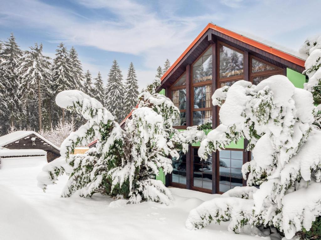 a cabin in the woods with snow covered trees at Holiday Home Jelení kout by Interhome in Smržovka