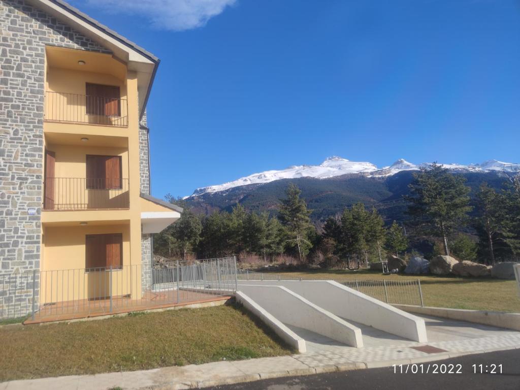 una rampa de skate frente a un edificio con montañas en Apartamento a estrenar en Villanúa, en Villanúa