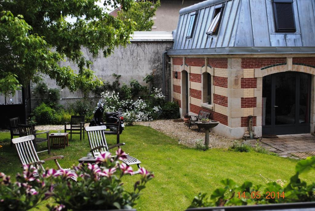 a yard with chairs and a building with a fireplace at "Maison Schott" Studio in Nancy