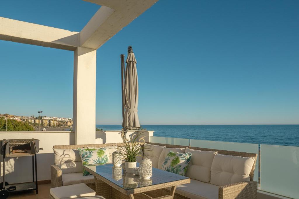 un patio con mesa y vistas al océano en Apartamentos Varadero On the beach, en Cala del Moral