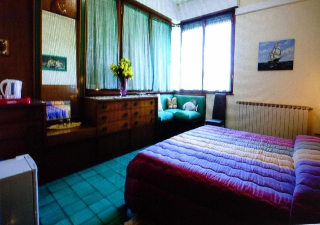 sypialnia z dużym łóżkiem i lustrem w obiekcie VILLA MIMOSA Splendida Vista Mare w mieście Bonassola