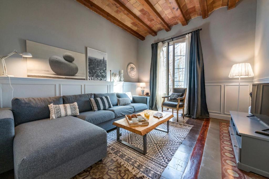 un soggiorno con divano blu e tavolo di Habitat Apartments Alaia a Barcellona