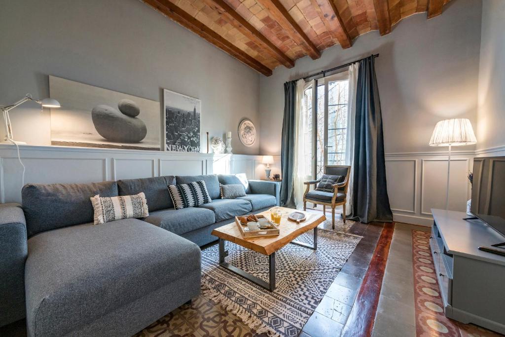 een woonkamer met een blauwe bank en een tafel bij Habitat Apartments Alaia in Barcelona