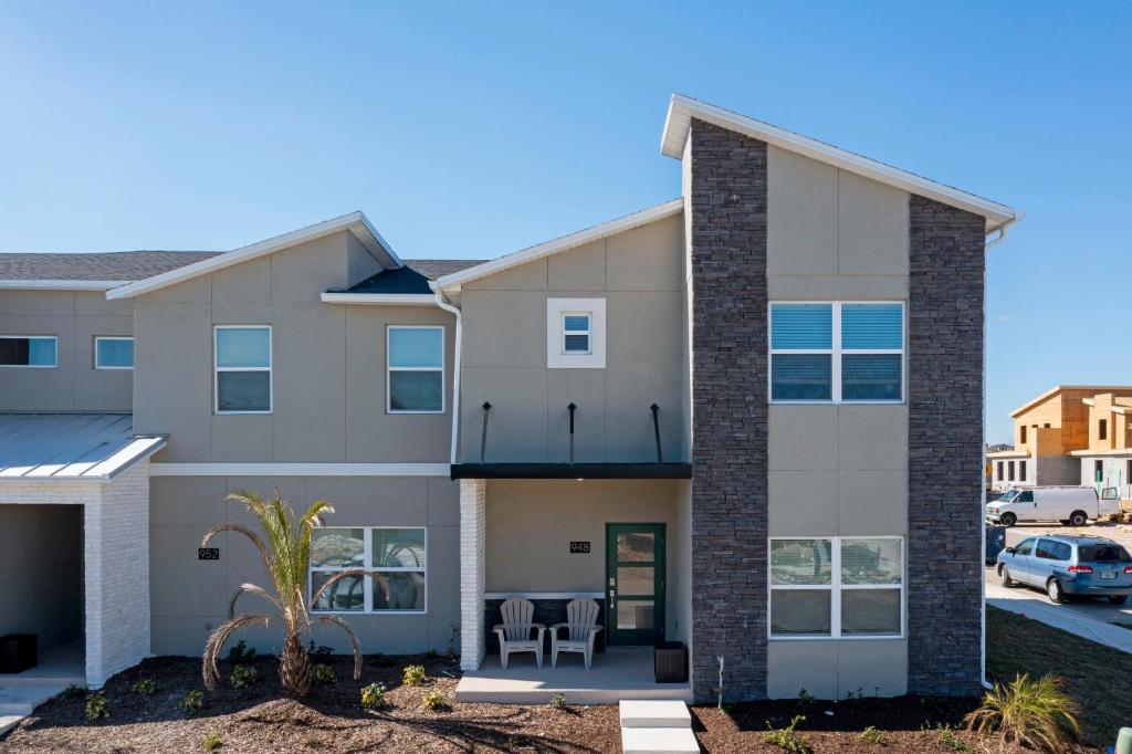 aominium building with a patio in a parking lot at Gorgeous 5 Bd w/ Pool Close to Disney @ Champions Gate 948 in Kissimmee