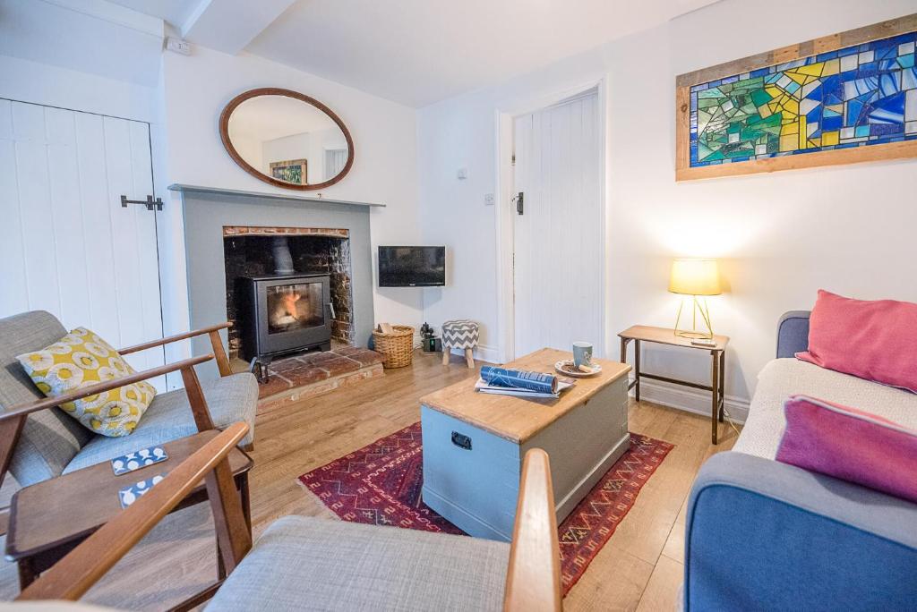 a living room with a couch and a fireplace at 2 Riverside Cottages in Saxmundham
