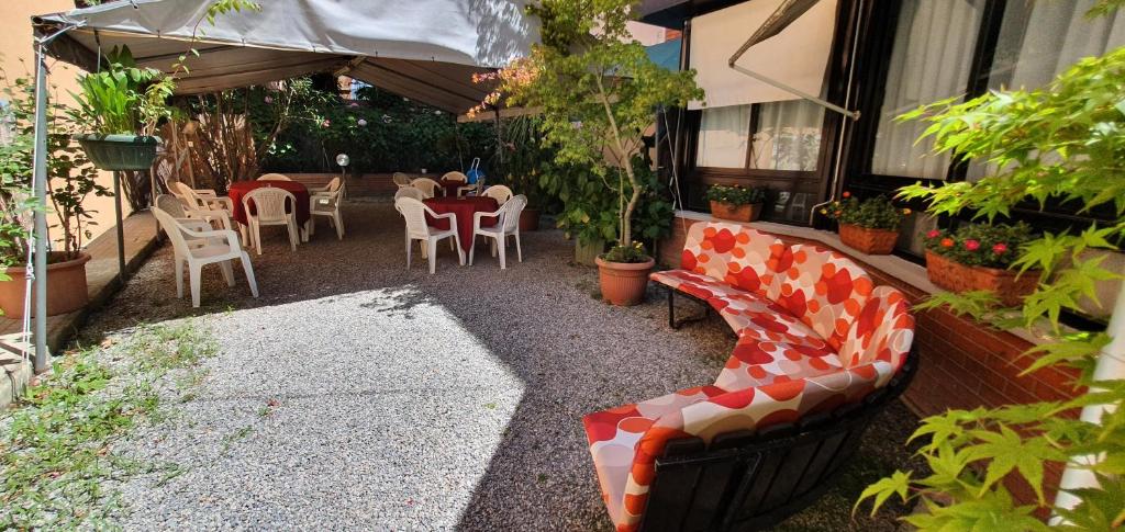 a patio with a bench and a table and chairs at Hotel Giovanna in Montecatini Terme