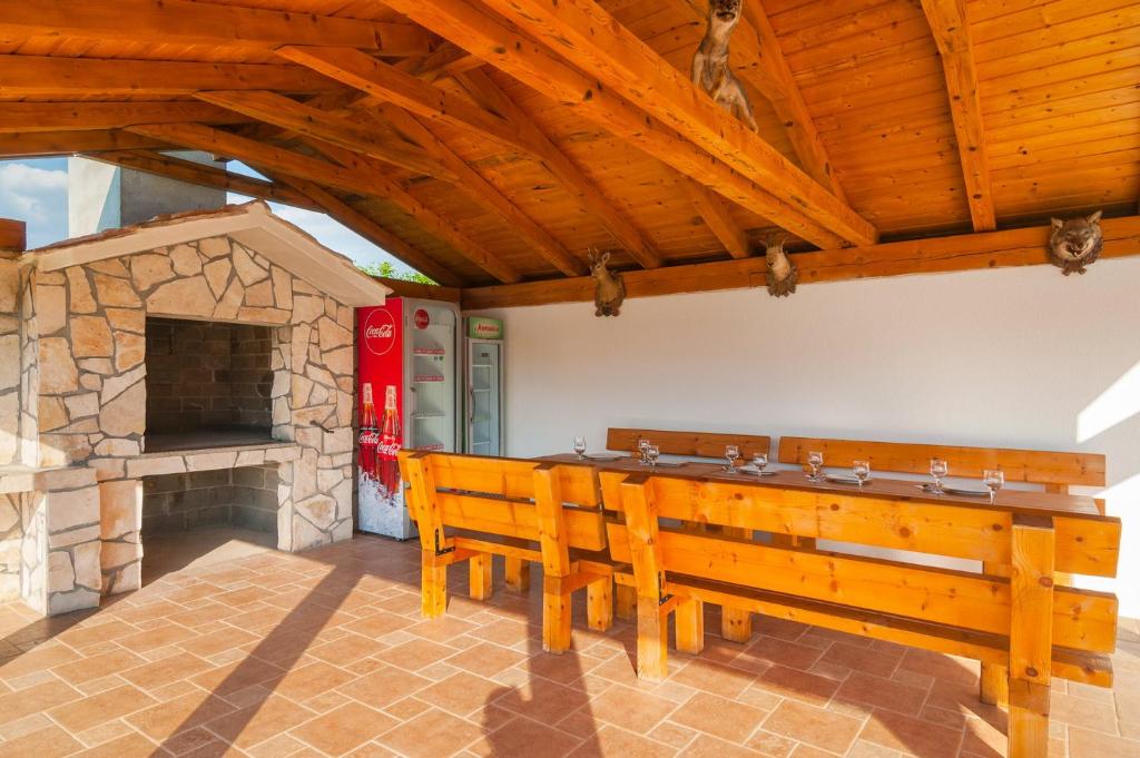 a patio with two benches and a stone fireplace at Vila M&M in Slivno