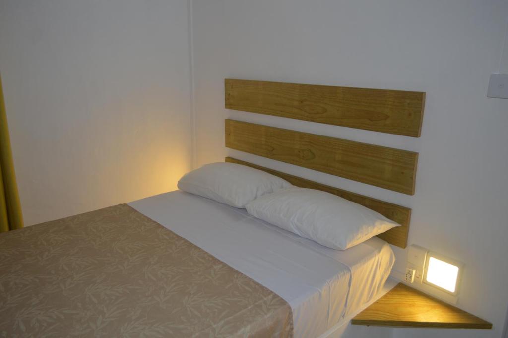 a bed with two pillows in a small room at Bluestar Appartement 4, centre de Grand Baie in Grand Baie