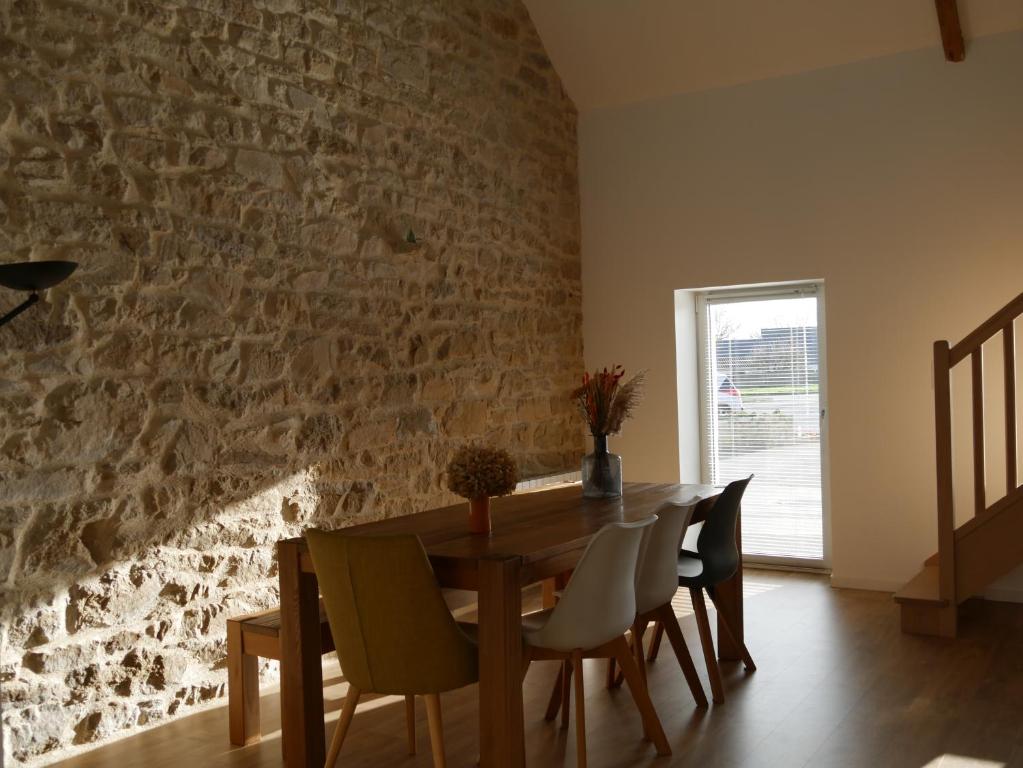 comedor con mesa de madera y sillas en * LA CAMPAGNE AU BORD DE LA MER *, en Locoal-Mendon