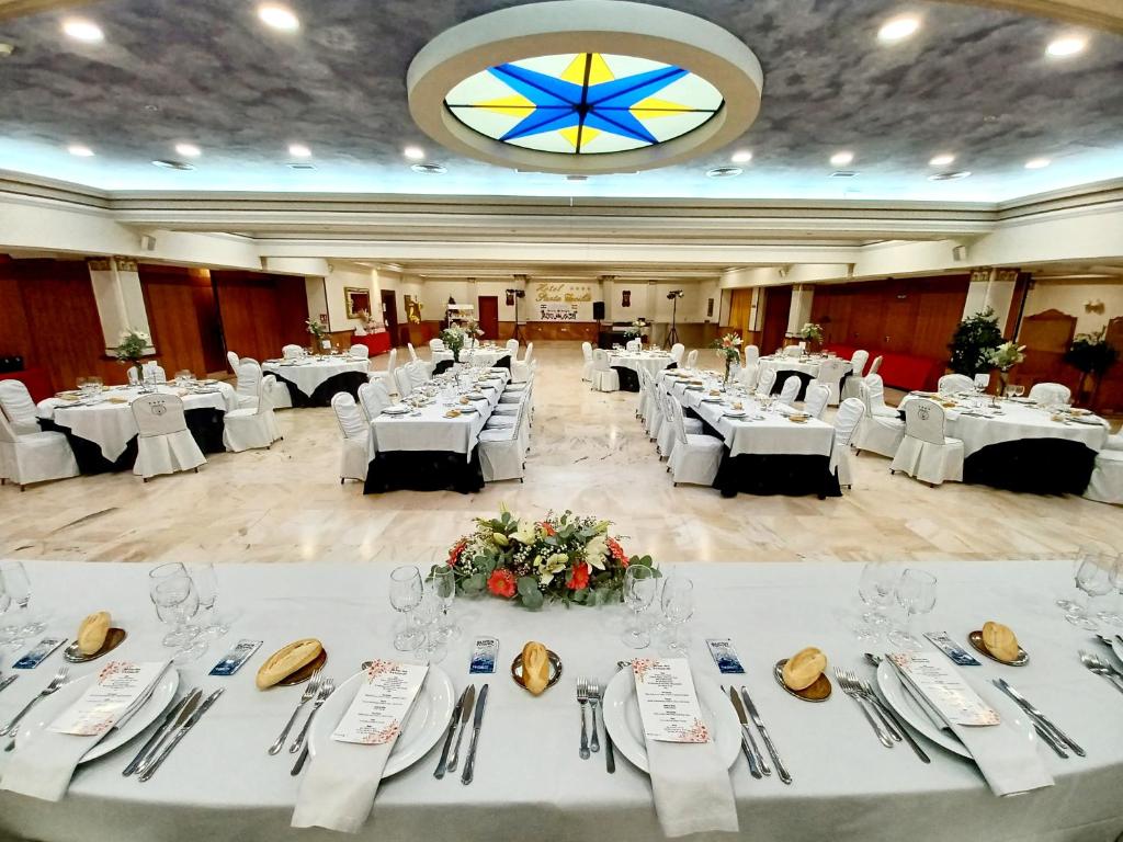 Hotel Santa Cecilia في سيوداد ريال: قاعة احتفالات كبيرة بها طاولات وأواني بيضاء