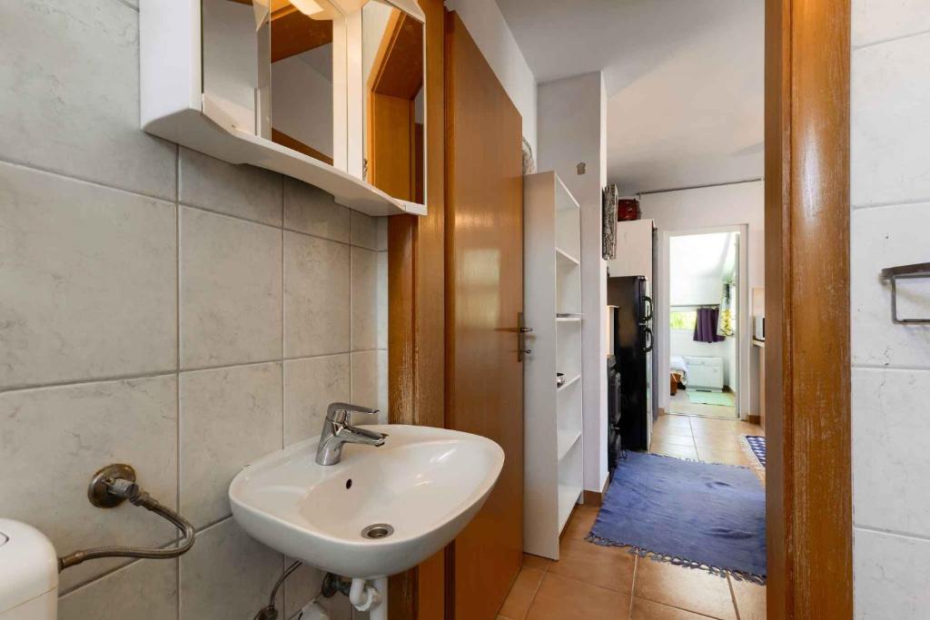 biała łazienka z umywalką i korytarzem w obiekcie Apartments in Vir/Insel Vir 34750 w mieście Vir