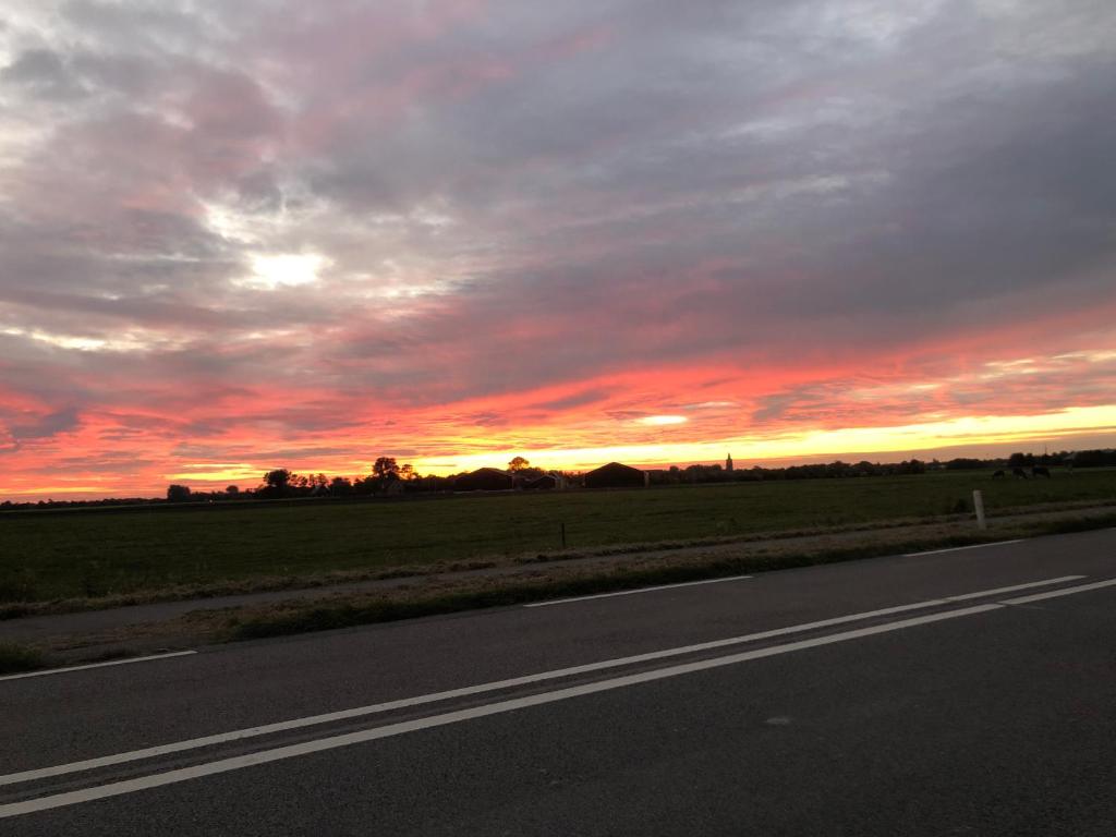 una strada vuota con un tramonto nel cielo di Ironico Homestay Bostalsee Ferienwohnung 100 m2 a Eisen