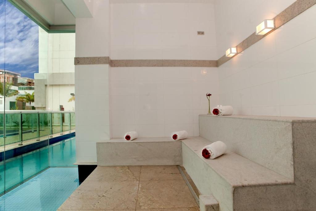 a room with a bench and a swimming pool at Jade Hotel Brasília in Brasilia
