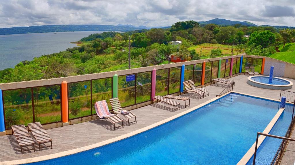 a balcony with a swimming pool and chairs and the water at Monte Terras in Tronadora