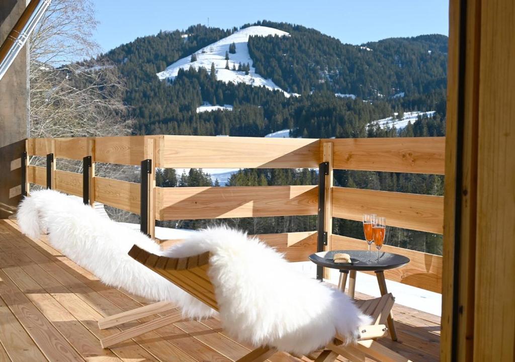 a balcony with a bench with white feather cushions at Chalet Dahuim in Balderschwang