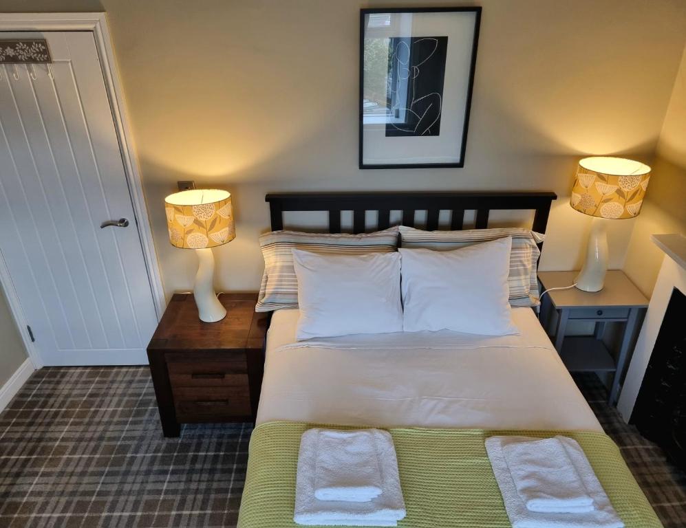 sypialnia z łóżkiem i 2 lampkami na stołach w obiekcie Apartment 11, Mirfield, West Yorkshire w mieście Mirfield
