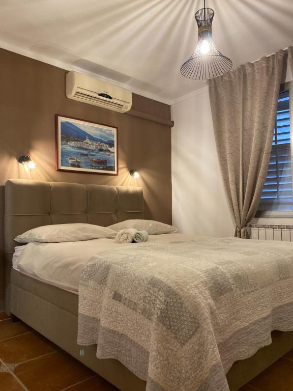 a bedroom with a bed with a blanket and a window at Apartments Oliva in Poreč