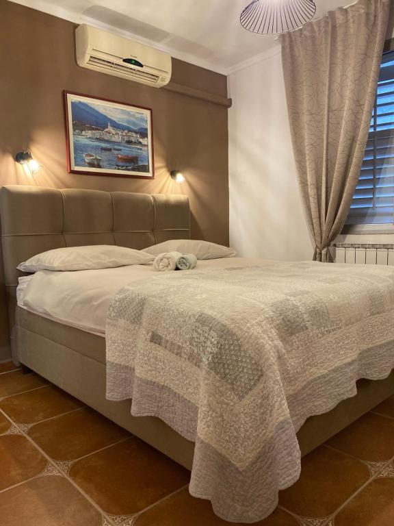 a bedroom with a bed with a blanket on it at Apartments Oliva in Poreč