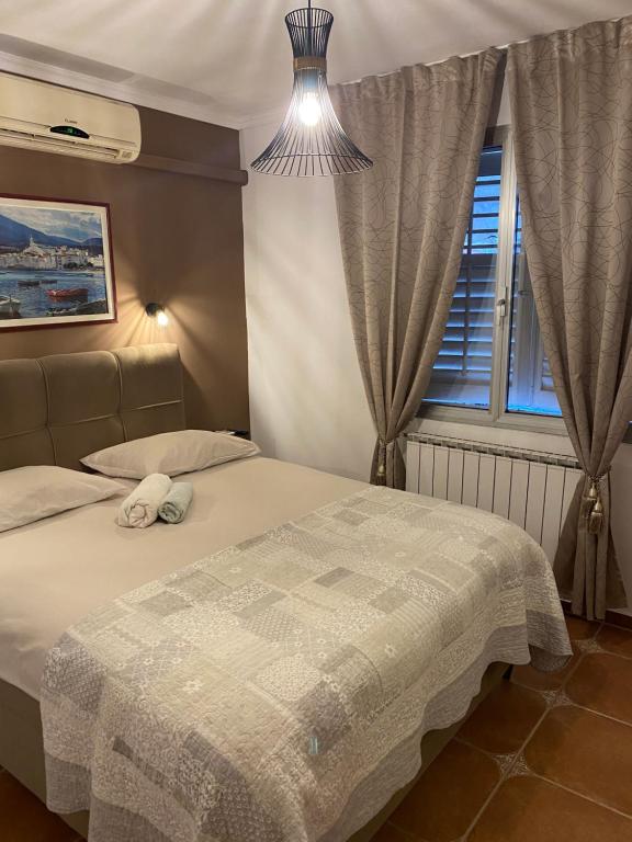 a bedroom with a bed and a window at Apartments Oliva in Poreč