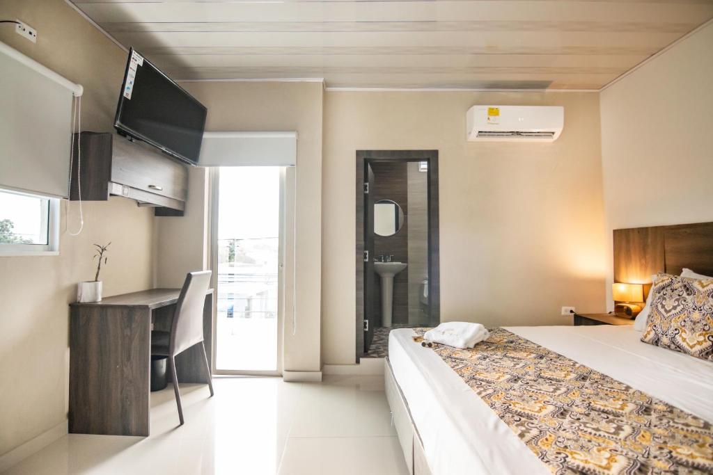 a hotel room with a bed and a bathroom at Cienaguas Hotel in Ciénaga