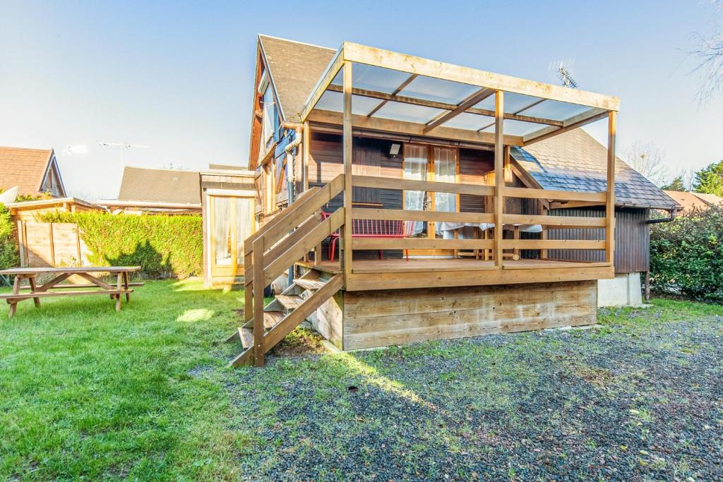 une maison en bois avec un escalier dans une cour dans l'établissement Calm chalet close to Cabourg center - Welkeys, à Cabourg