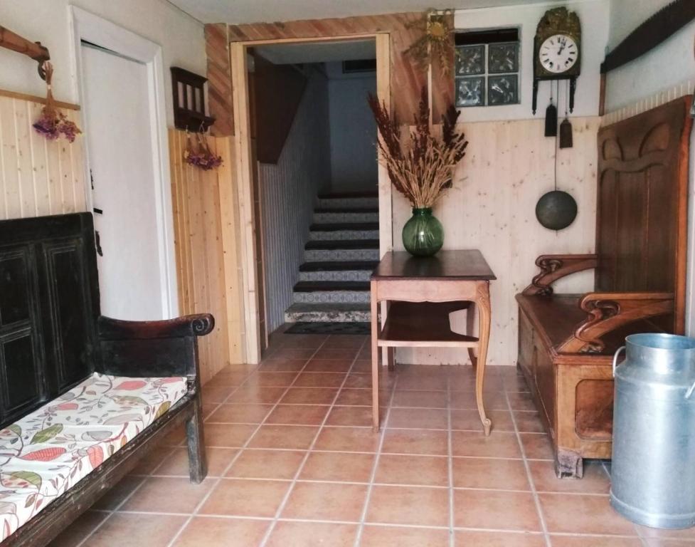 a room with a staircase and a table and a clock at 643km landa etxea in Villatuerta
