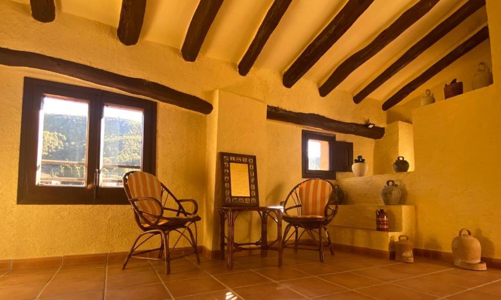 Habitación con 2 sillas, mesa y ventana en Cals Piris Casa Rural, en Cabacés