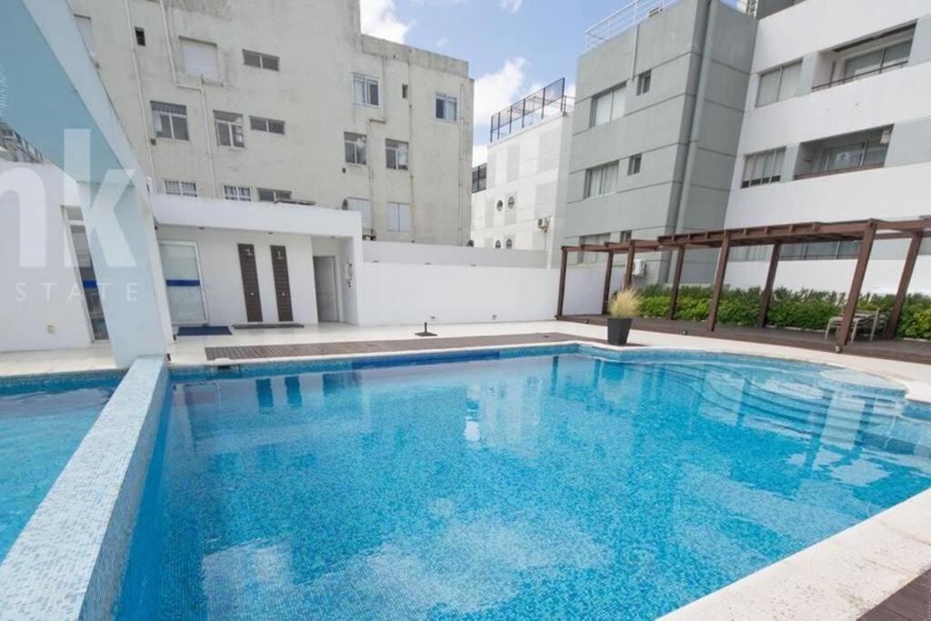 una gran piscina frente a un edificio en Moderno Apartamento en la Península, en Punta del Este