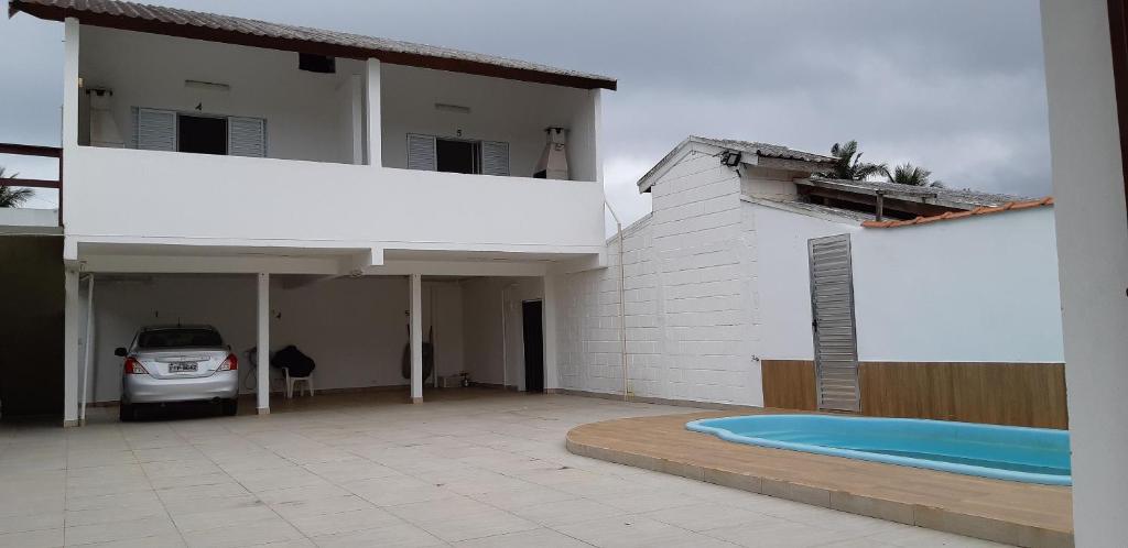 una casa bianca con piscina in un vialetto di 0006.04 - Maranduba - KitNet 1º Andar - 4 Pessoas - 3 Quadras Do Mar - Piscina Coletiva - WIFI a Ubatuba