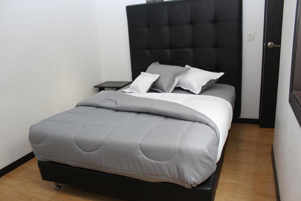 a bedroom with a large bed with a black headboard at Hotel Montecarlo Boutique in Bogotá